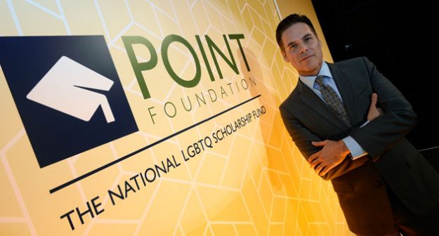 Point Foundation CEO Jorge Valencia next to banner 