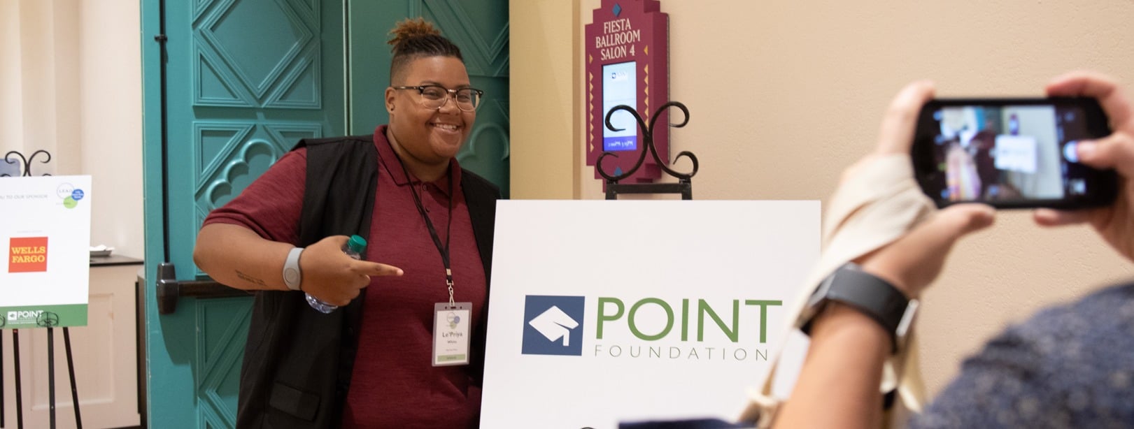 point scholar smiling pointing at sign